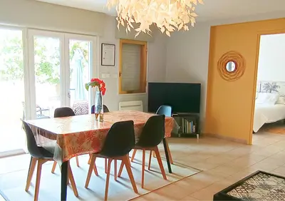 a living room with a dining room table and chairs at Jardin-Marin-Ajaccio in Ajaccio
