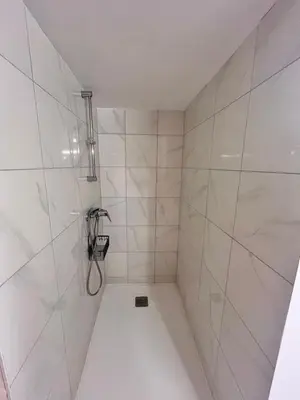 a bathroom with a shower with white tiles at Jardin-Marin-Ajaccio in Ajaccio
