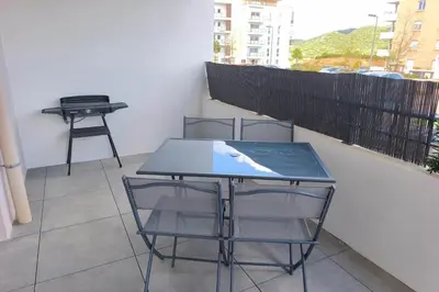 a room with a balcony with chairs and a table at T2 apartment with terrace in Ajaccio