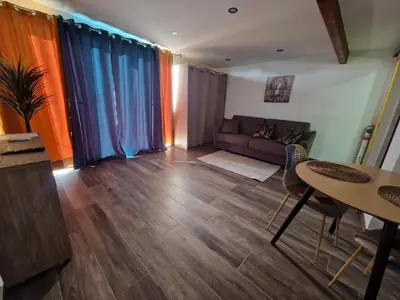 a living room with a couch and a table at Agréable studio in Afa