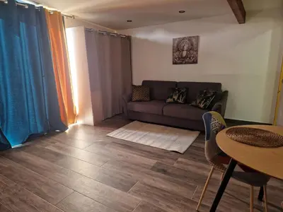 a living room with a couch and a table at Agréable studio in Afa