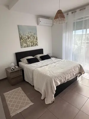 a bedroom with a bed and a painting on the wall at Charmant 2 pièce tout équipé climatisé in Sainte-Lucie de Porto-Vecchio