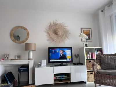 a living room with a tv on a white cabinet at Charmant 2 pièce tout équipé climatisé in Sainte-Lucie de Porto-Vecchio