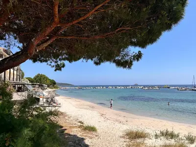 a beach with a person standing in the water at Charmant 2 pièce tout équipé climatisé in Sainte-Lucie de Porto-Vecchio