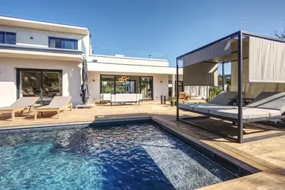 a pool with a bed and a house at La Villa Luxury Green patio in Cirendinu