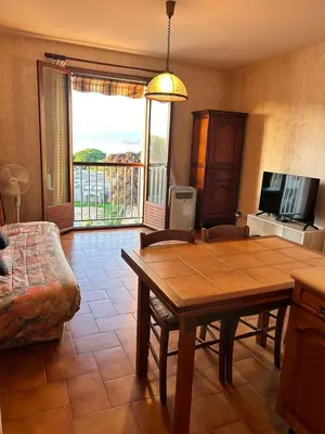 a living room with a table and a couch at Studio PORTICCIO in Porticcio