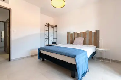 a bedroom with a bed with a blue blanket at A Nepita - 150m de la plage in Pietrosella