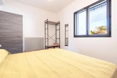 a bedroom with a large bed and a window at A Nepita - 150m de la plage in Pietrosella
