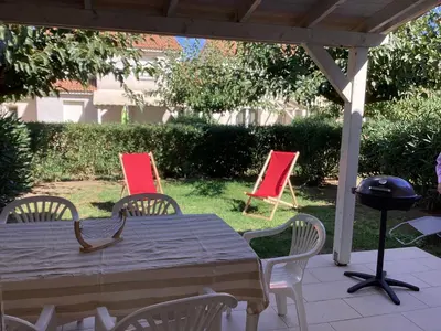 a table and chairs in a yard with red chairs at La BénéCIOLA, vue Mer, Box Fibre SFR, High Speed Internet in Cervione