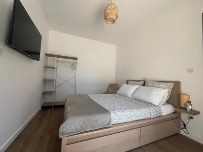 a bedroom with a bed and a flat screen tv at A Felicità in Sainte-Lucie de Porto-Vecchio