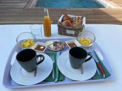 a tray with cups and plates and a basket of food at A Felicità in Sainte-Lucie de Porto-Vecchio