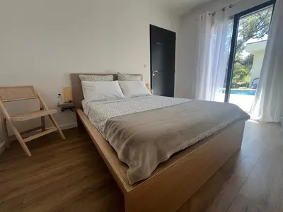 a bedroom with a large bed with a large window at A Felicità in Sainte-Lucie de Porto-Vecchio