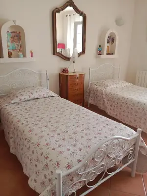 a bedroom with two beds and a mirror at Maison des pruniers in Furiani