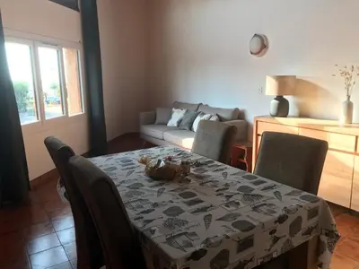 a dining room with a table and chairs and a couch at Studio bord de mer in Lecci