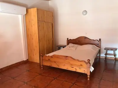 a bedroom with a wooden bed and a wooden cabinet at Studio bord de mer in Lecci
