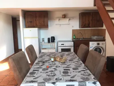 a kitchen with a dining room table with chairs and a tableablish at Studio bord de mer in Lecci