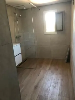 a bathroom with a shower with a glass door at Studio bord de mer in Lecci