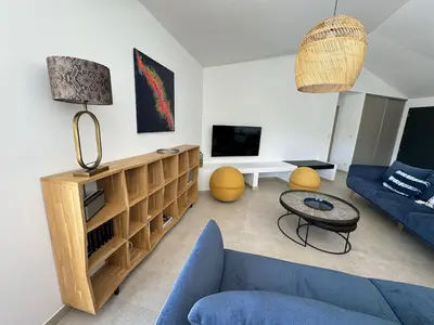 a living room with a blue couch and a tv at Villa Bavella in Zonza
