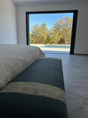 a bedroom with a bed and a large window at Villa Bavella in Zonza