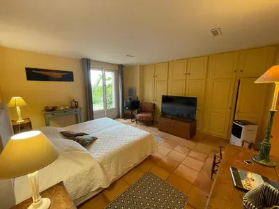 a bedroom with a bed and a flat screen tv at Villa L'usciata in Pietrosella