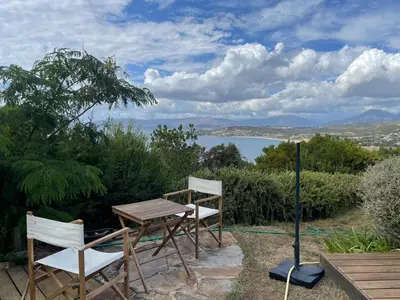 a table and two chairs and a table with a view of the water at Villa L'usciata in Pietrosella