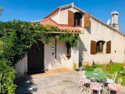 a house with a table and chairs in front of it at Casa Scaglione in Porticcio