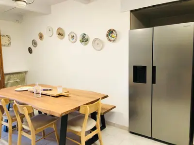 a kitchen with a wooden table and a refrigerator at Casa Scaglione in Porticcio