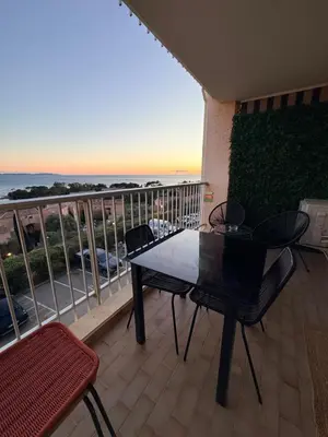 a patio with two chairs and a table and a balcony at Studio front de Mer Sanguinaires in Ajaccio