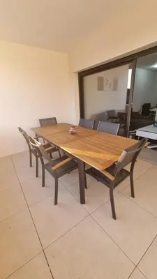 a wooden dining room table with chairs around it at Bel Appartement F3 proche de la plage in Pietrosella
