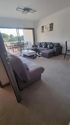 a living room with a couch and a table at Bel Appartement F3 proche de la plage in Pietrosella
