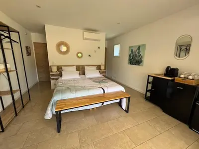 a bedroom with a bed and a table in it at Résidence Patios di Pruno in Figari