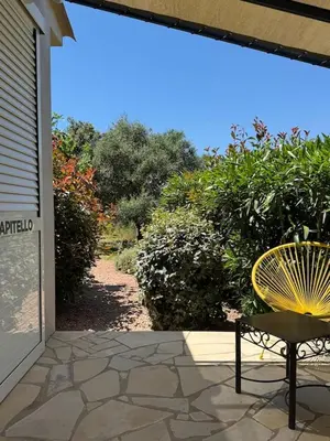a yellow chair sitting on a patio next to a door at Résidence Patios di Pruno in Figari