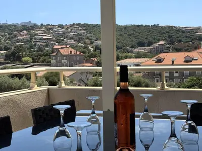 a bottle of wine sitting on a table with wine glasses at Joli T2 idéalement situé in Propriano