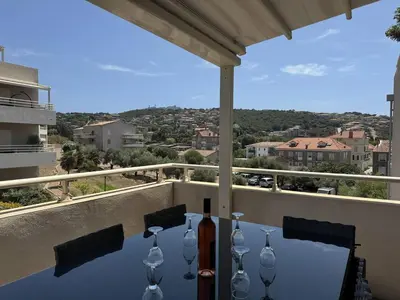 a table with wine glasses on top of a balcony at Joli T2 idéalement situé in Propriano