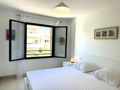a bedroom with a white bed and a window at Joli T2 idéalement situé in Propriano