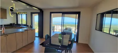 a kitchen with a table and a view of the ocean at O SOHNO 4 pers vue Mer Piscine in Sainte Trinité