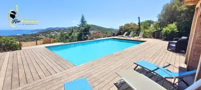 a swimming pool on a wooden deck with chairs at O SOHNO 4 pers vue Mer Piscine in Sainte Trinité