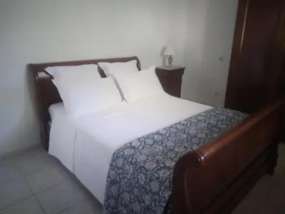 a bed with white sheets and pillows in a room at Entre mer et maquis- maison avec piscine privée - 8 minutes plage tizzano in Sartène