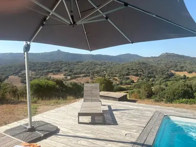 an umbrella and a bench next to a swimming pool at Entre mer et maquis- maison avec piscine privée - 8 minutes plage tizzano in Sartène