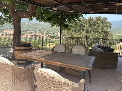 a wooden table and chairs on a patio at Entre mer et maquis- maison avec piscine privée - 8 minutes plage tizzano in Sartène