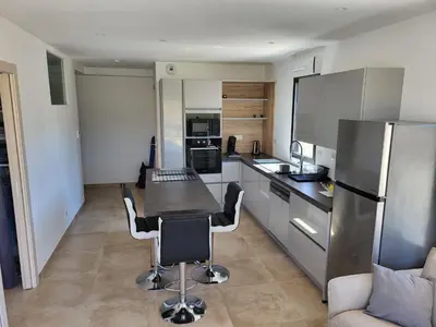 a kitchen with a table and chairs and a refrigerator at Porticcio - Agosta Plage - T2 - Chez Cath et JC in Albitreccia