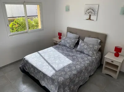 a bedroom with a bed with two red candles on it at Les arbousiers de Murateddu in Porto-Vecchio