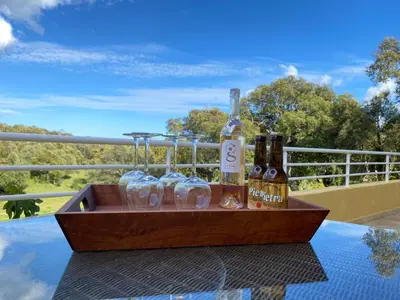 a wooden tray with bottles and glasses on a table at Les arbousiers de Murateddu in Porto-Vecchio