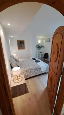 a bedroom with a bed and a wooden door at Casa di leo in Figari