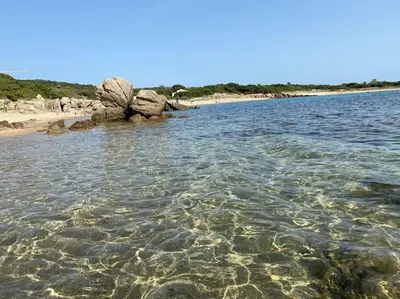 a body of water with rocks and a beach at Casa di leo in Figari