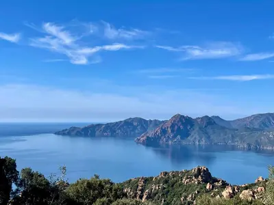 a view of a large body of water with mountains at Appartement spacieux avec vue mer in Piana