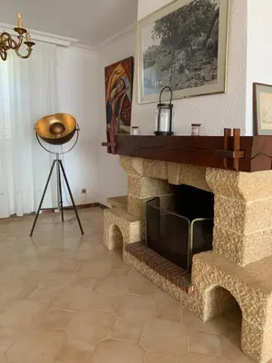 a living room with a stone fireplace and a tripod at Appartement spacieux avec vue mer in Piana
