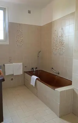 a large bathroom with a tub and a sink at Appartement spacieux avec vue mer in Piana