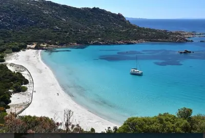 an aerial view of a beach with turquoise water at U caseddu di Monacia in Monacia-dʼAullène