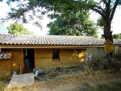 a small house with a sign on the side of it at chalet 4 à 6 pers à la campagne 15 mn plages et Ajaccio grand terrain arboré calme assuré in Afa